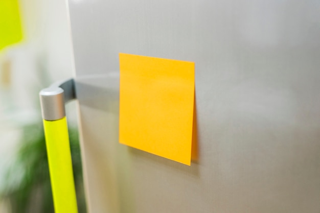 Free photo yellow sticky note on fridge