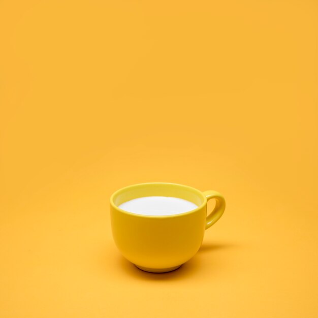 Желтый натюрморт чашки молока