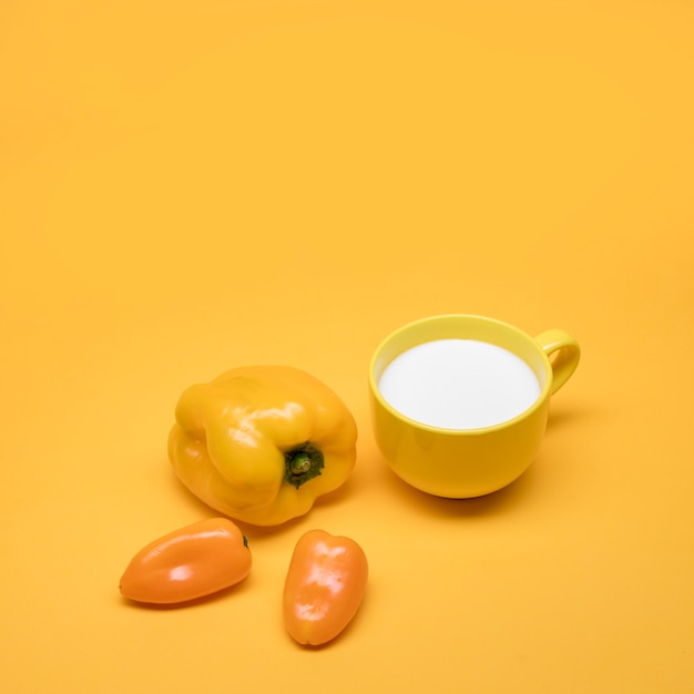 Yellow still life of milk and peppers