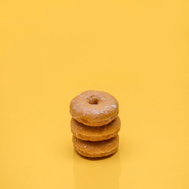 Yellow still life of three donuts