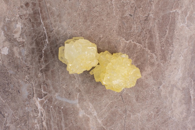 Free photo yellow sugar candies on marble table .