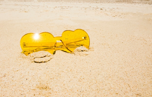 Foto gratuita occhiali da sole gialli sulla spiaggia