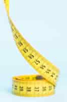 Free photo yellow tape measure on blue background