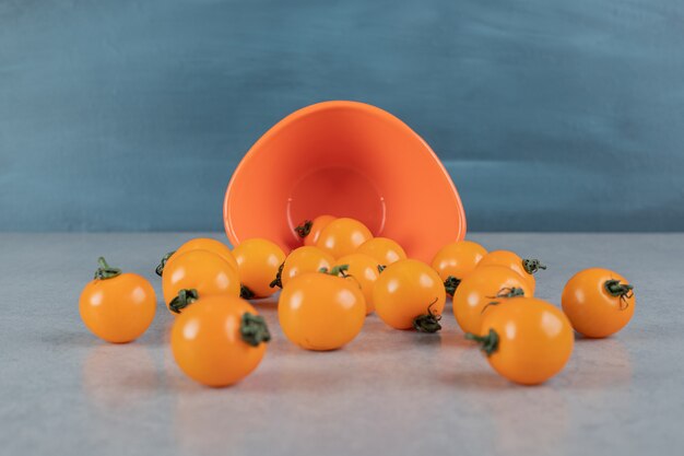 Yellow tomatoes isolated on stone surface