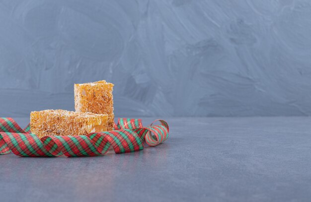 Yellow traditional turkish delight with peanuts on grey background.