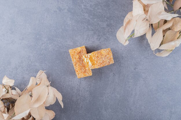 Yellow traditional turkish delight with peanuts over grey background.