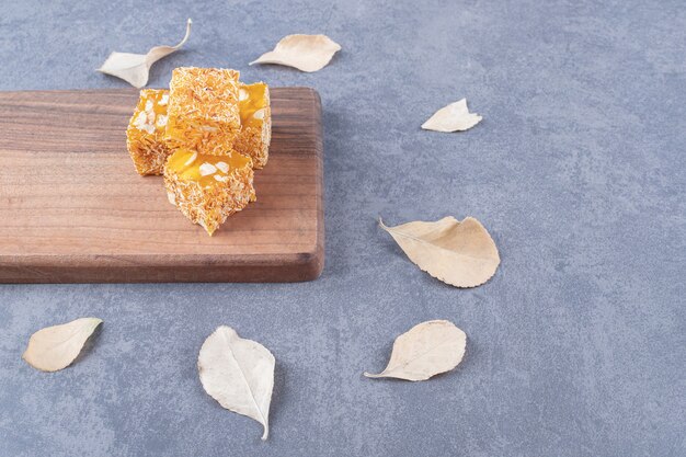 Yellow traditional turkish delight with peanuts on wooden board