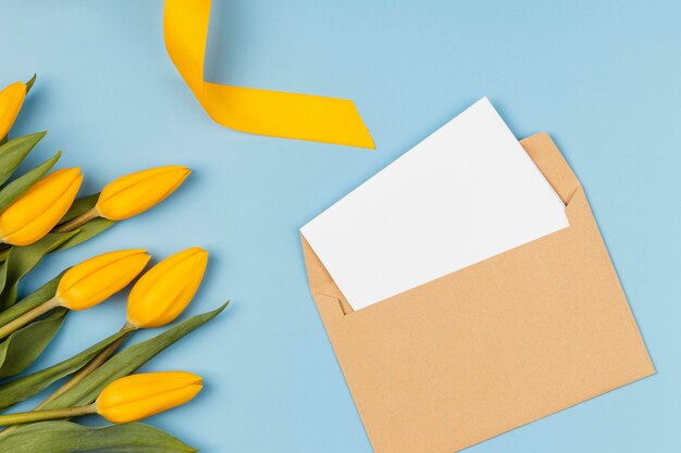 Yellow tulips with blank card in envelope