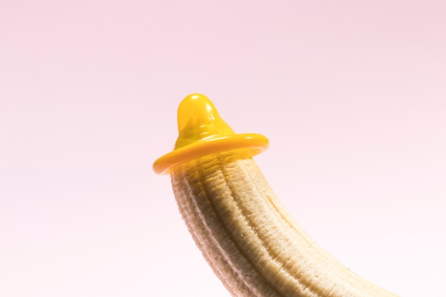 Yellow unwrapped condom on a banana 