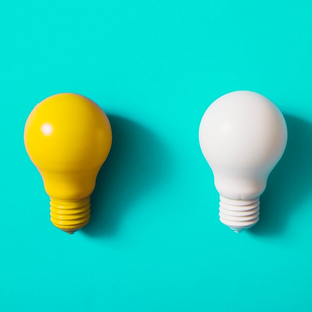 Yellow and white light bulb on turquoise background