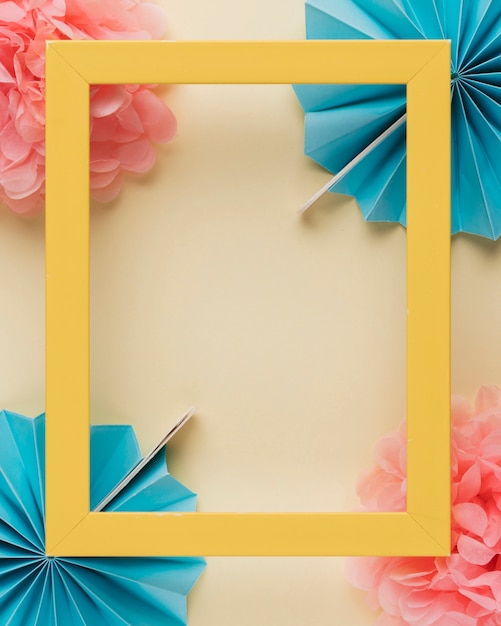 Желтая деревянная рамка для фотографий на бумажном цветке на бежевом фоне