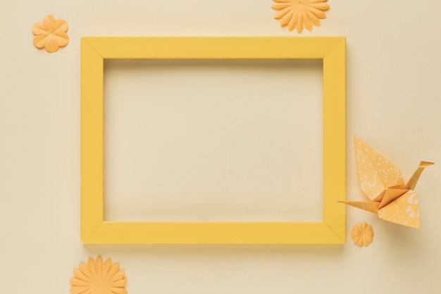 Желтая деревянная рамка с бумажной птицей и цветочным вырезом