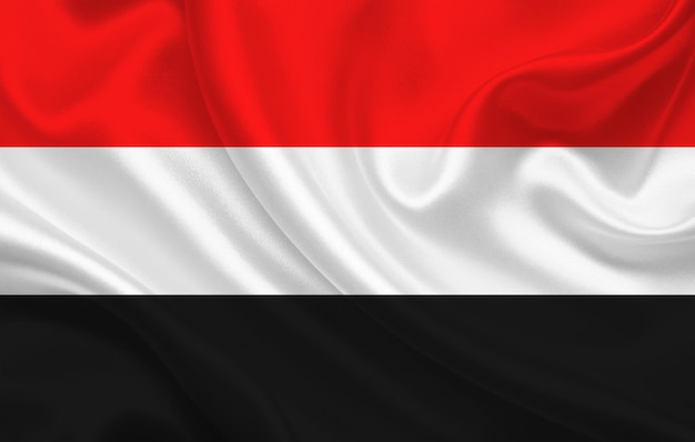 Yemen country flag on wavy silk fabric background panorama - illustration
