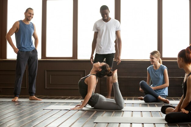 Yoga instructor performing raja bhudjangasana advanced exercise