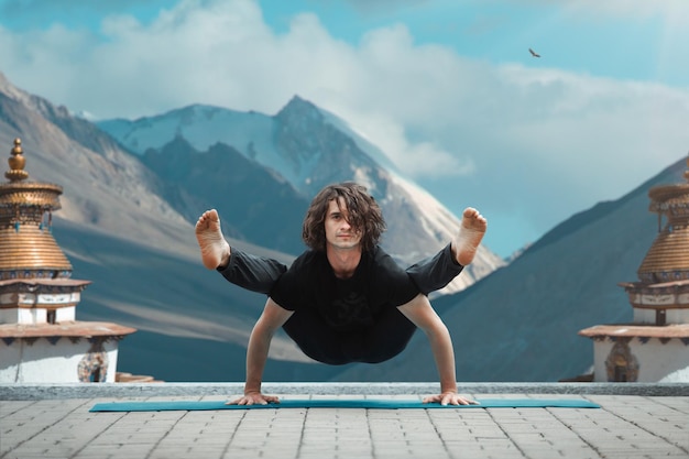 Foto gratuita uomo di yoga giovane che fa yoga in loft all'alba