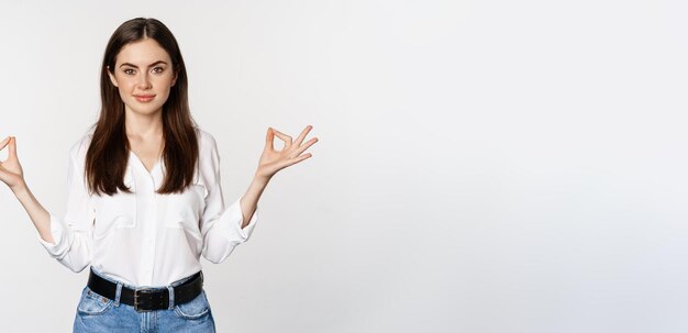 Yoga and mindfulness young woman meditating with closed eyes breathing freely and showing mudra nirv