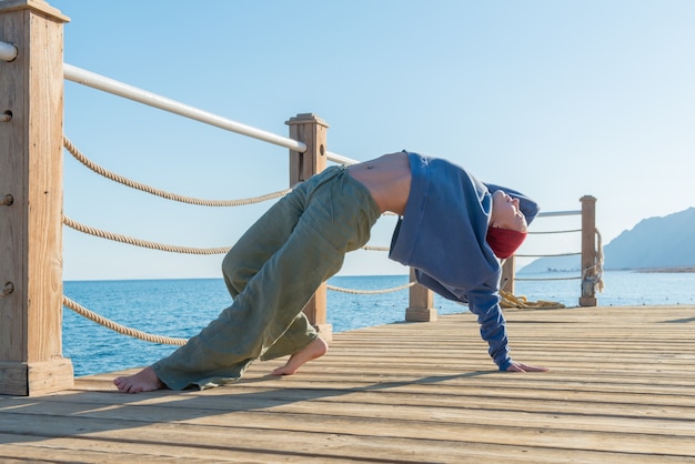 Foto gratuita la pratica dello yoga al molo