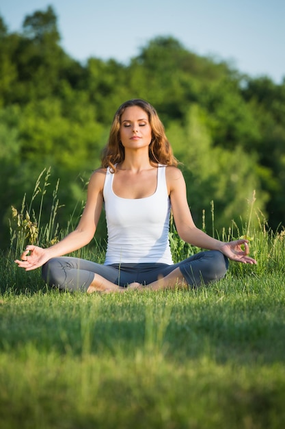 Yogi girl meditating with nature. Girl in lotus pose thinking about beautiful spirit.