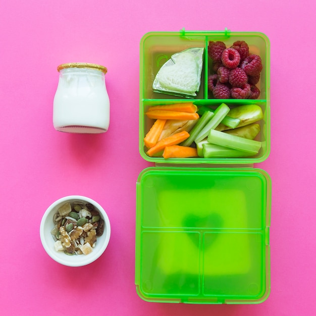 Yogurt and muesli near lunchbox with healthy food