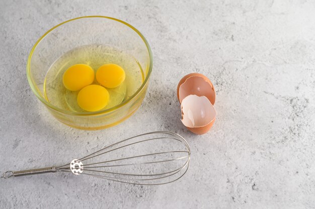 Yolk in glass bowl and eggshell