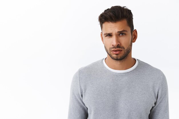 You talking to me Arrogant and skeptical goodlooking bearded macho guy in grey sweater looking disbelief and questioned expression raise eyebrow arched hesitant doubtful about offer