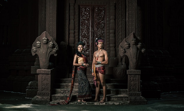 Free photo young actor and actress wearing beautiful ancient costumes, in ancient monuments, dramatic style. perform on legend love popular story, thai isan folktale called 