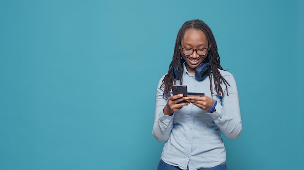 Young adult doing online shopping with credit card payment on smartphone app, buying from retail store website on sale discount. Woman making electronic transaction on mobile phone.