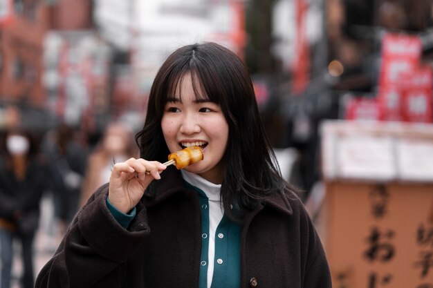 日本の屋台の食べ物を楽しむ若い大人