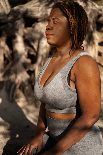 Free photo young adult enjoying yoga in nature