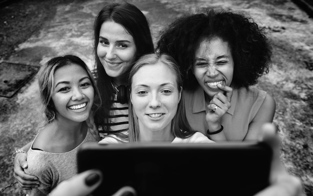Giovani amici della femmina adulta che prendono un selfie del gruppo