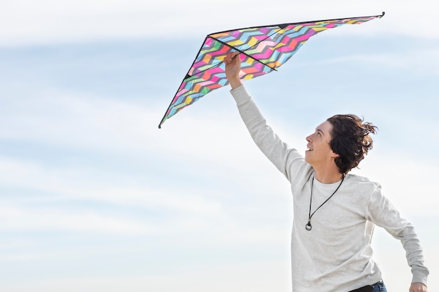 Free photo young adult having fun with kite