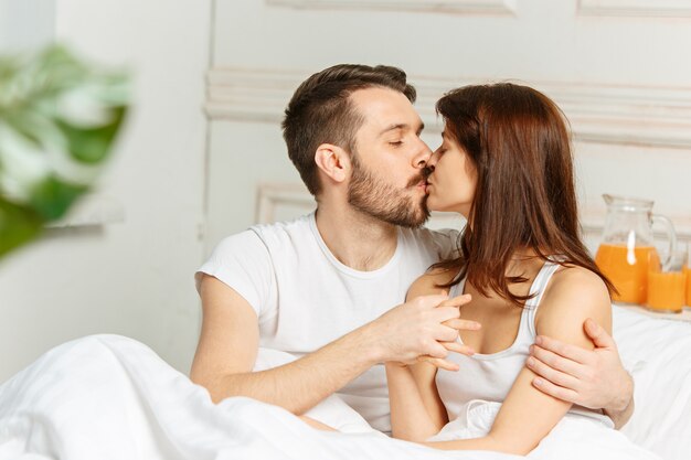 침실에서 침대에 누워 젊은 성인 이성애 커플