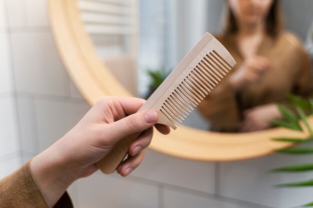 Young adult holding brush and comb