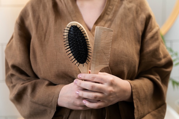 Young adult holding brush and comb