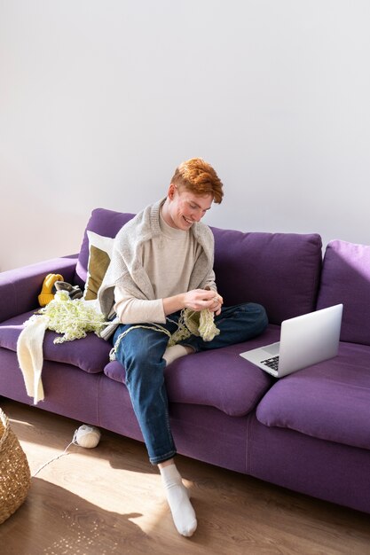 Young adult knitting at home