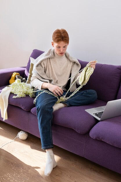 自宅で編み物をする若い大人