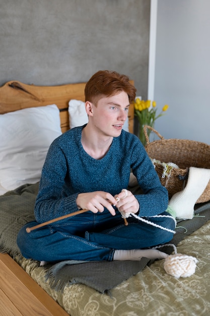 Young adult knitting at home