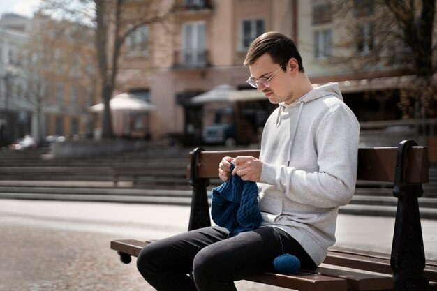 Young adult knitting outside