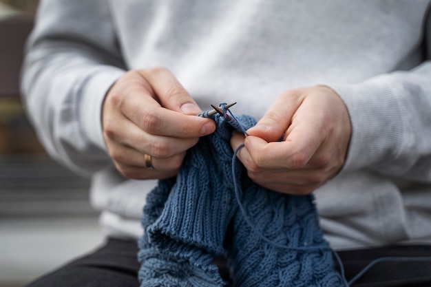 Young adult knitting outside