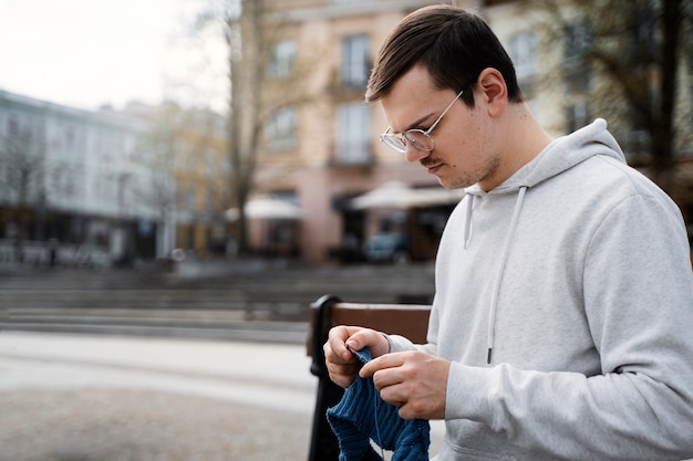 Young adult knitting outside