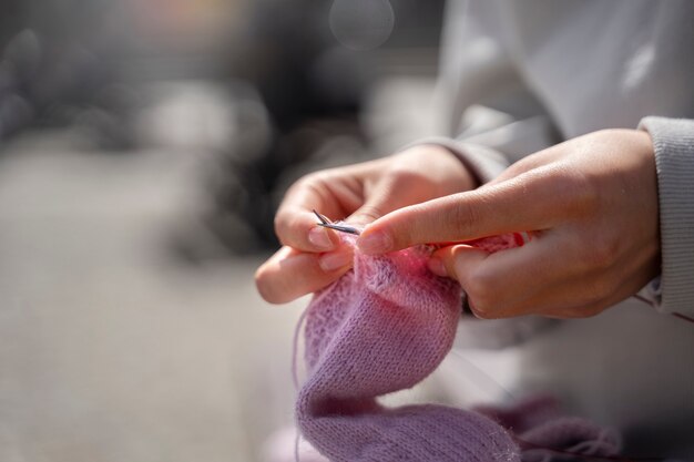 Young adult knitting outside