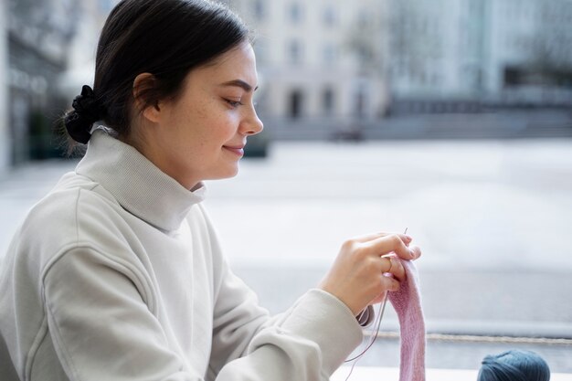 Young adult knitting outside