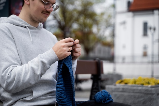 Giovani adulti che lavorano a maglia all'esterno