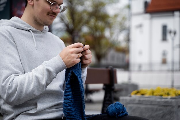 Young adult knitting outside