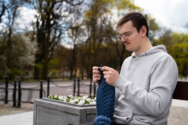 Young adult knitting outside