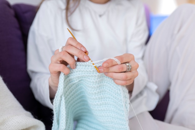 Young adult knitting together