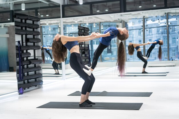 Young adult mother doing fitness with her little daughter