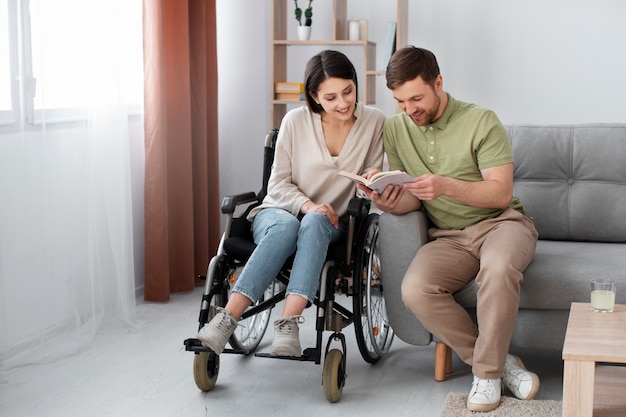 Young adult reading with disabled friend