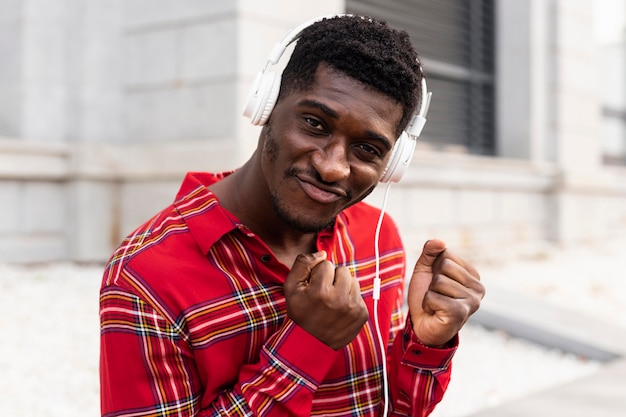 Young adult in red shirt listening to music on headphones