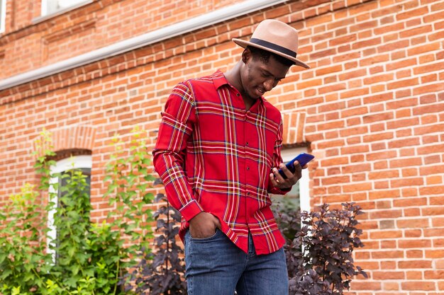 Young adult in red shirt looking at his phone